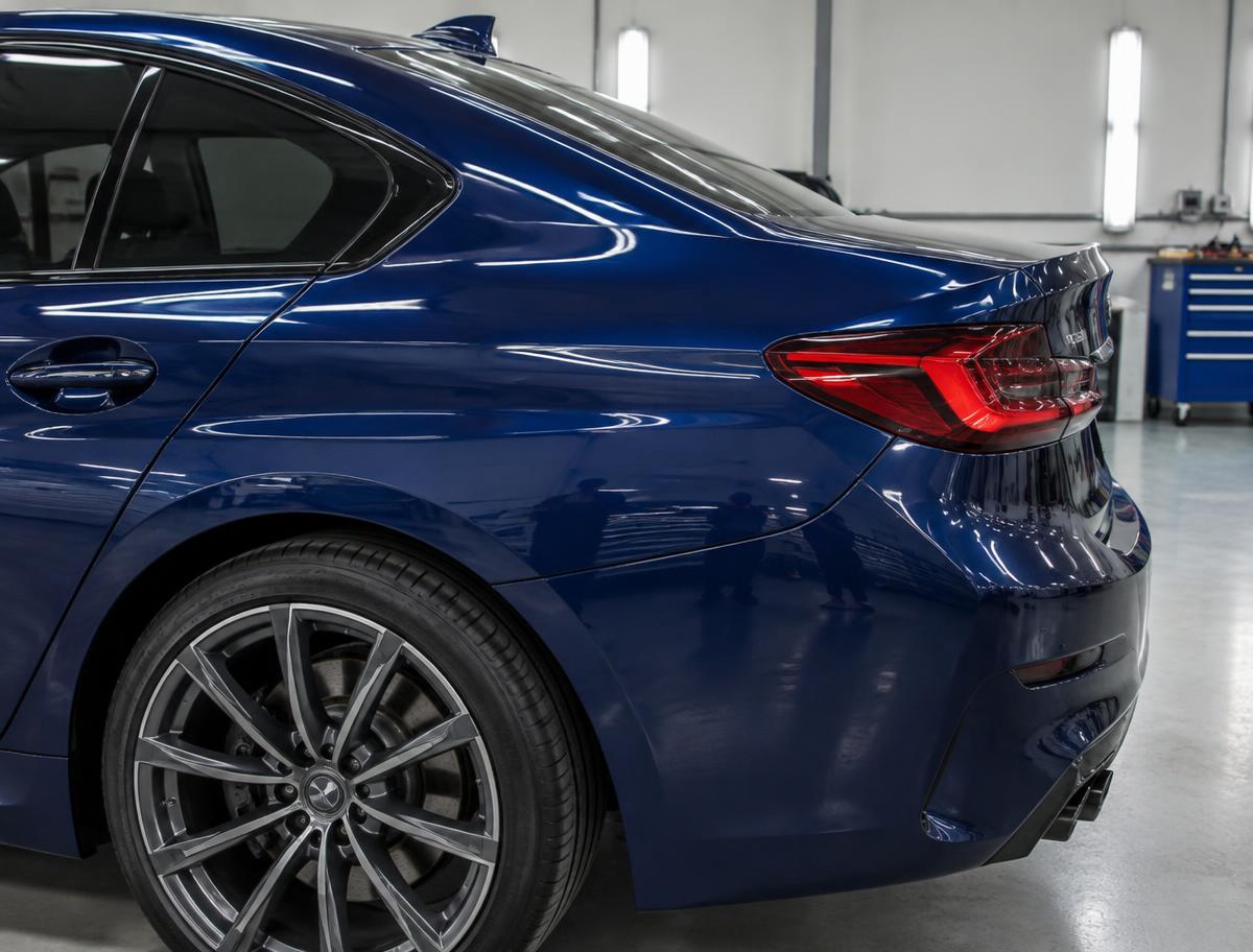 Deep blue sedan with smooth bodywork and matched paint after auto body repair